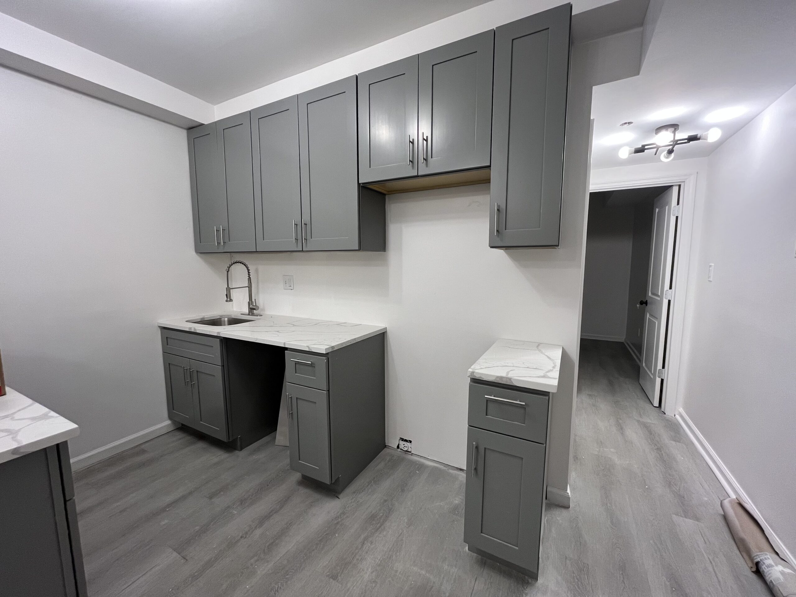 Gray Shaker cabinetry paired with quartz countertops creates a clean, timeless kitchen designed for everyday living.